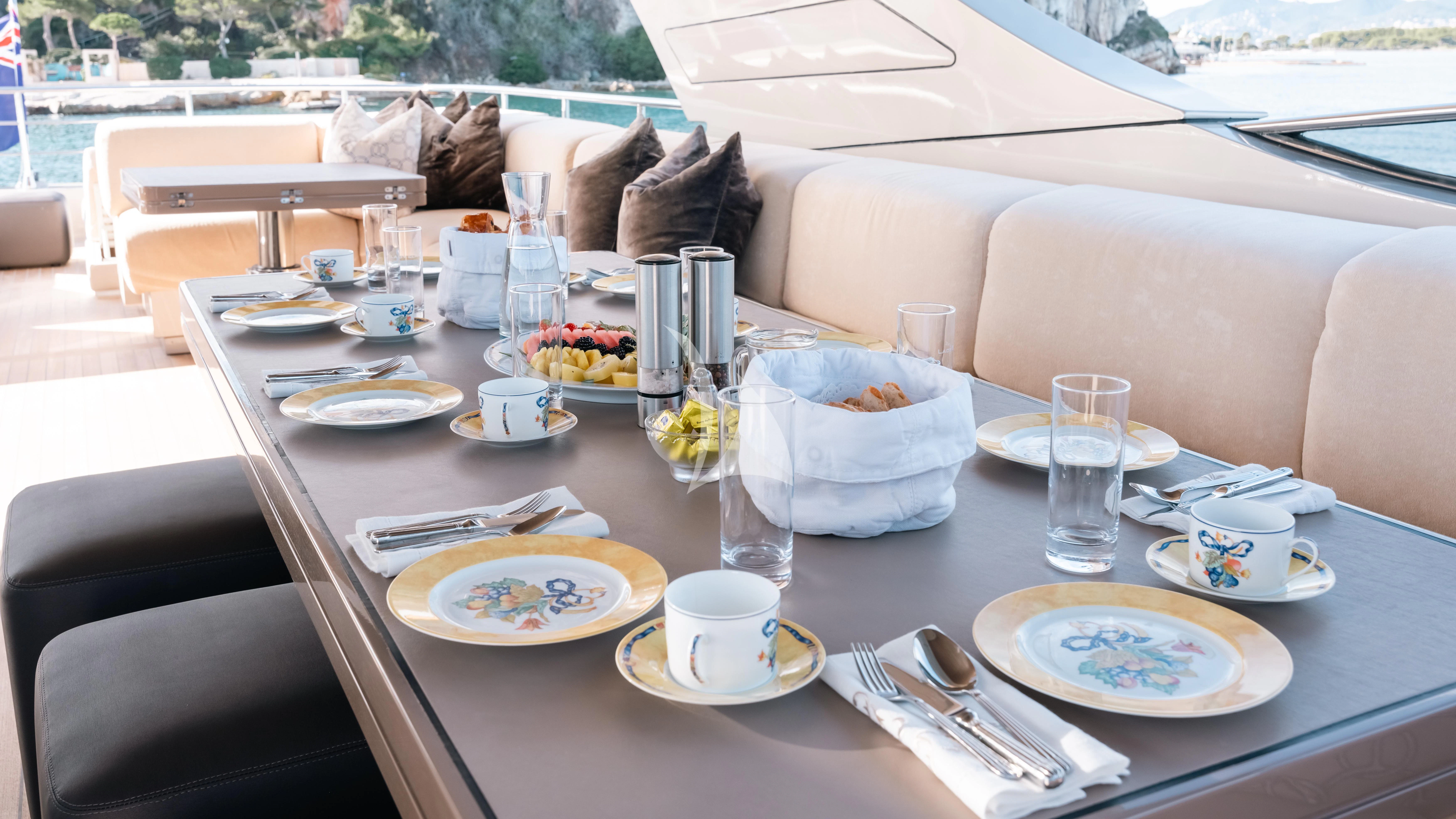 a table with plates and glasses on it aboard THE PALM Yacht for Sale