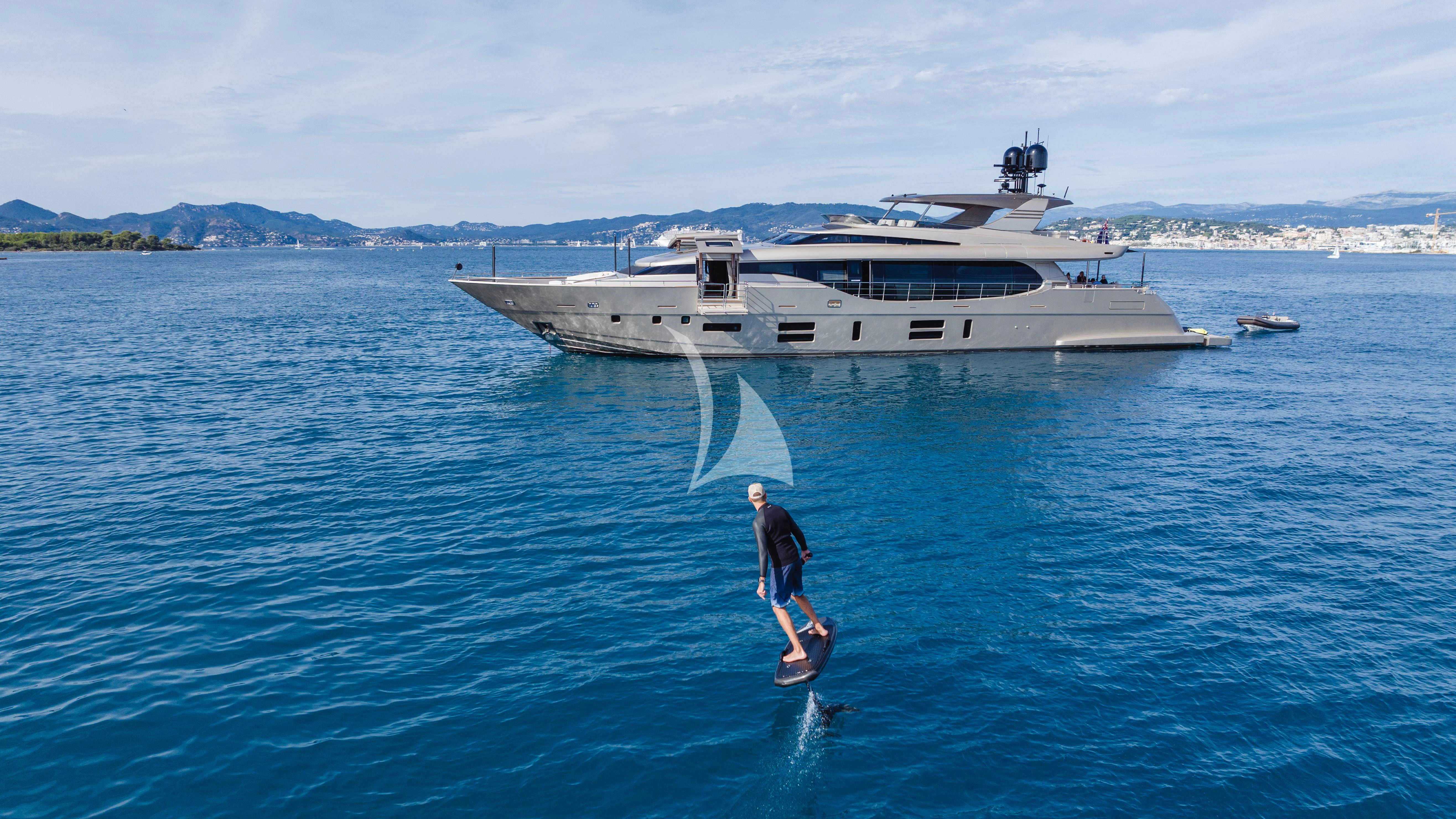 a person riding a surfboard in the water next to a boat aboard THE PALM Yacht for Sale