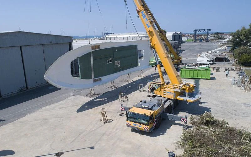 a yellow crane next to a building aboard THE PALM Yacht for Sale