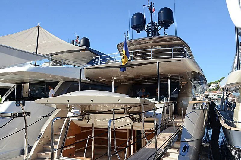 a boat docked with a person standing on the deck aboard THE PALM Yacht for Sale
