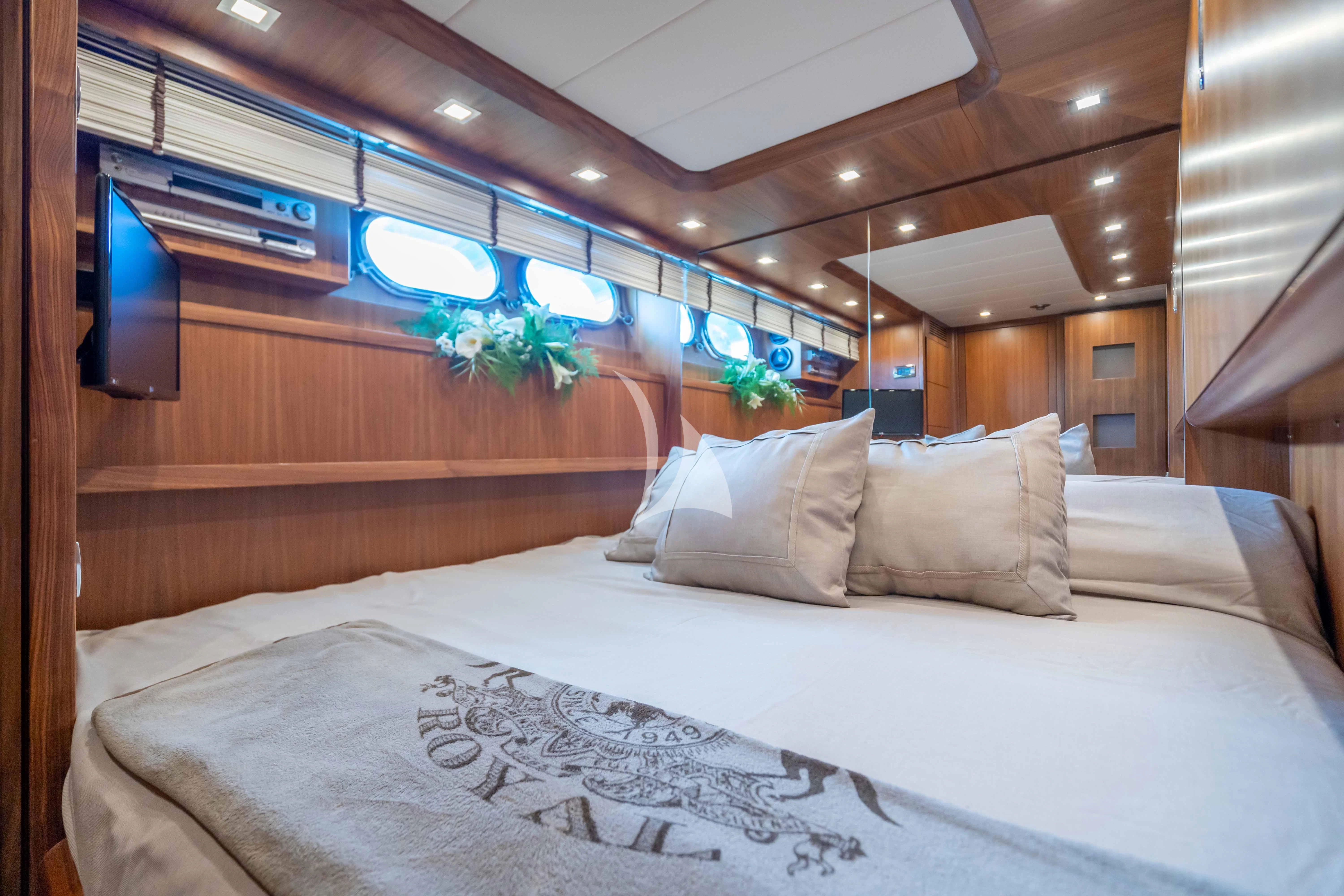 a bed with white sheets and pillows aboard LEX Yacht for Sale