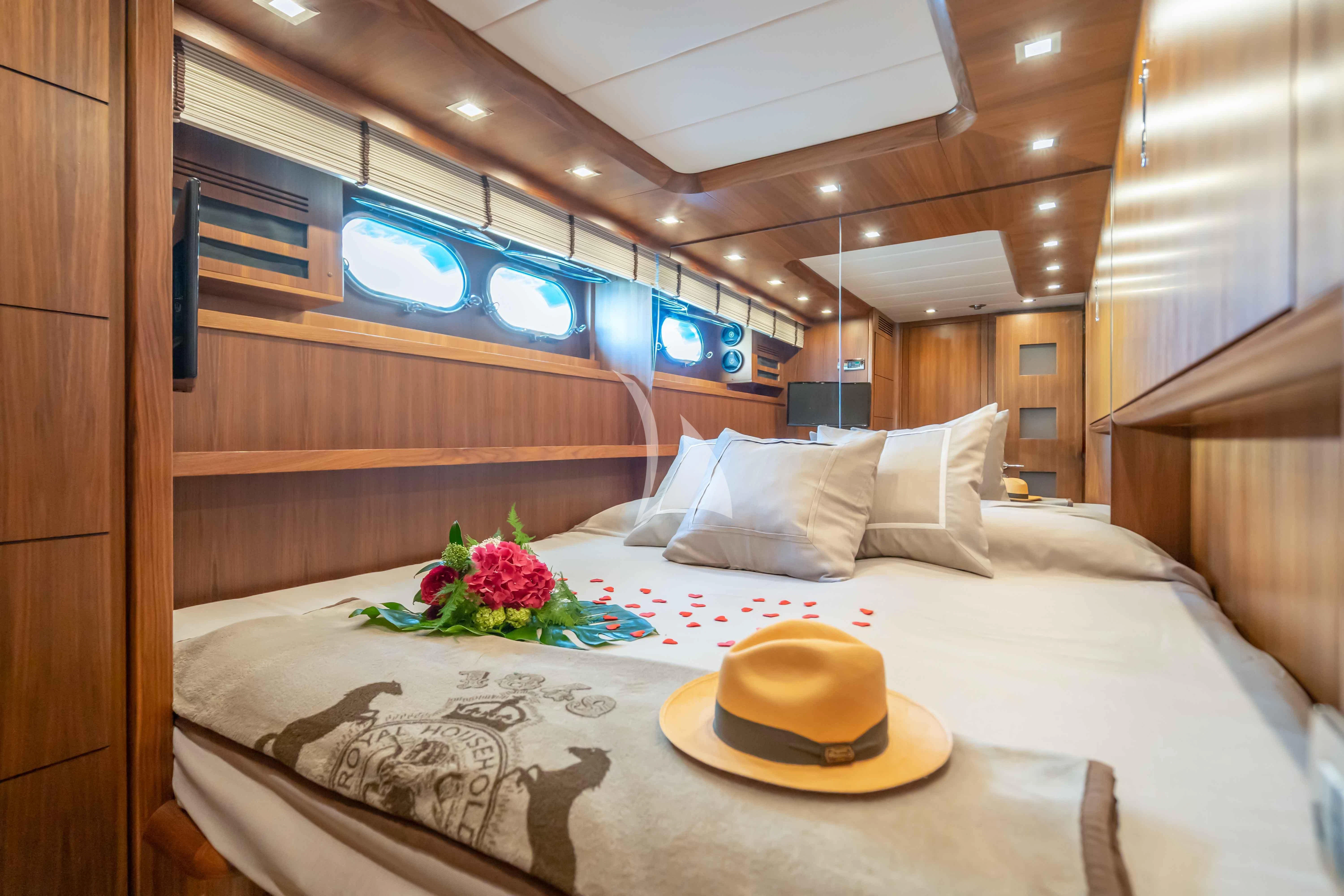 a bed with a hat on it aboard LEX Yacht for Sale