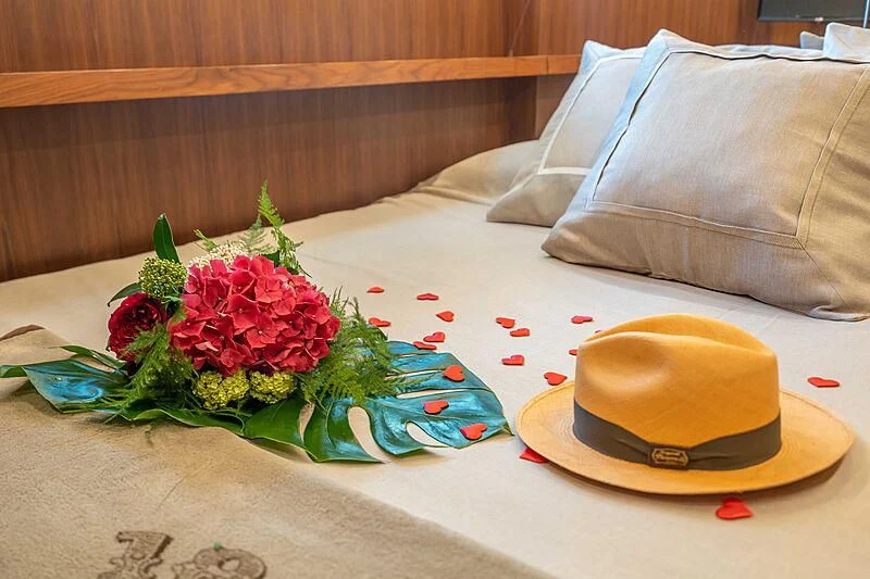 a hat on a bed aboard LEX Yacht for Sale