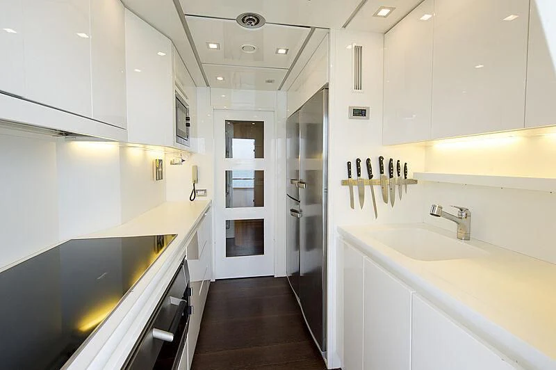 a kitchen with white cabinets aboard LEX Yacht for Sale
