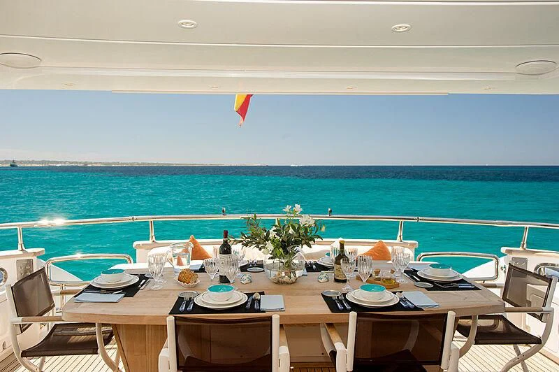 a table set for a dinner on a beach aboard LEX Yacht for Sale