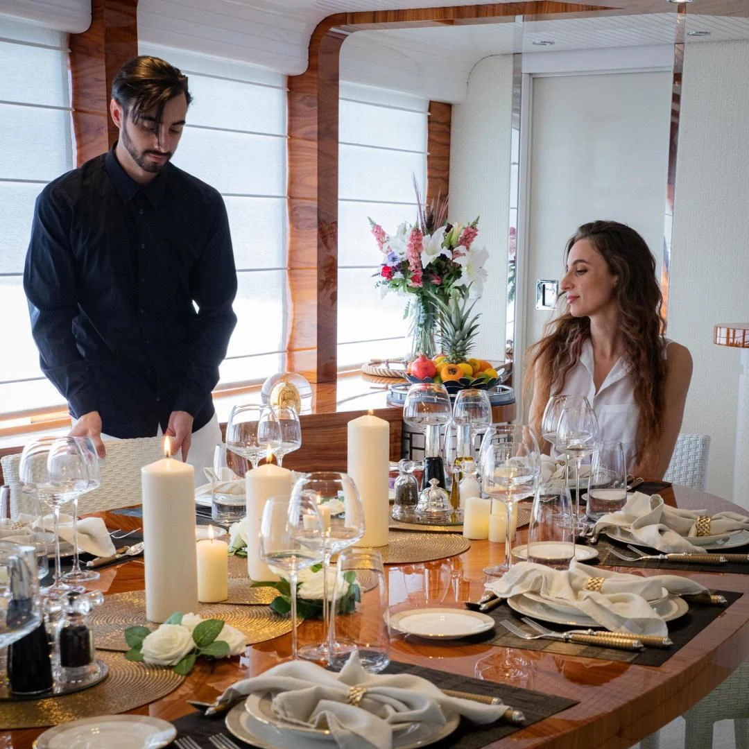 a man and woman at a dinner table aboard HATT MILL Yacht for Sale