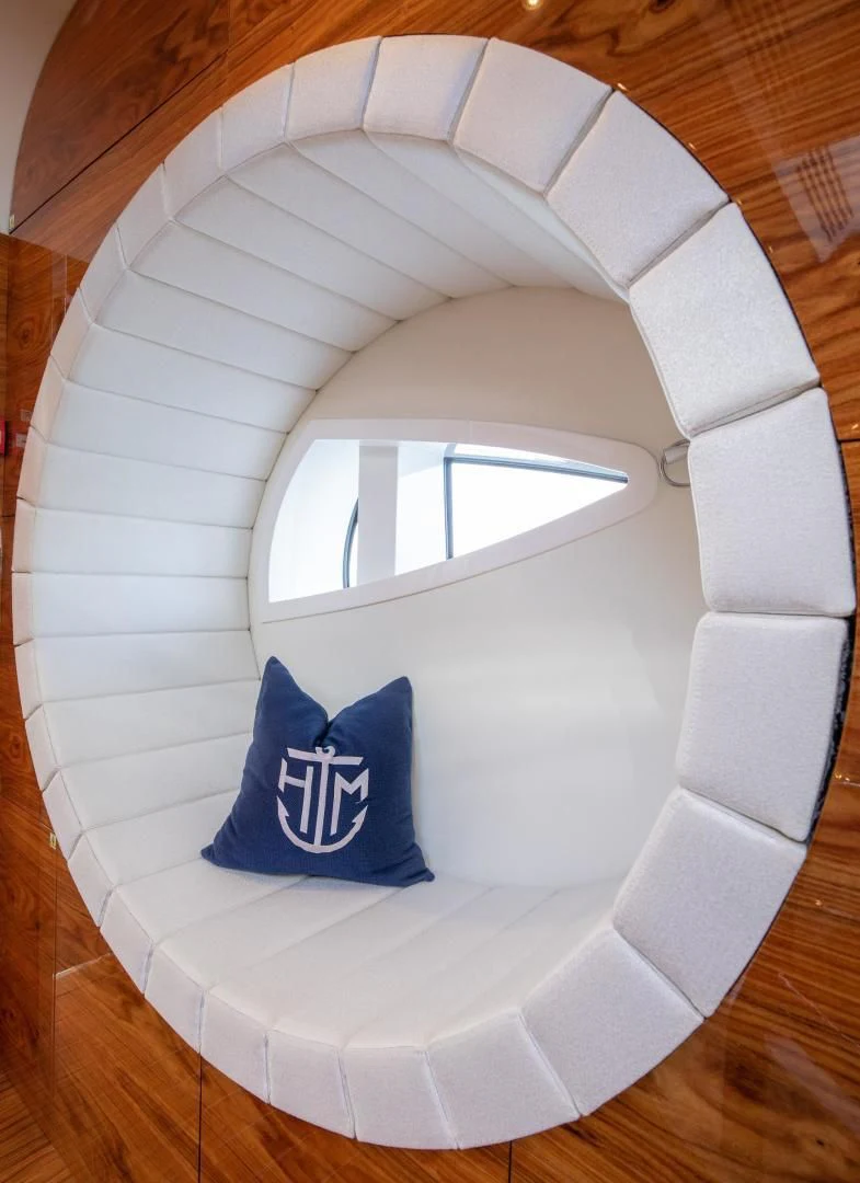 a white and blue pillow on a wooden floor aboard HATT MILL Yacht for Sale