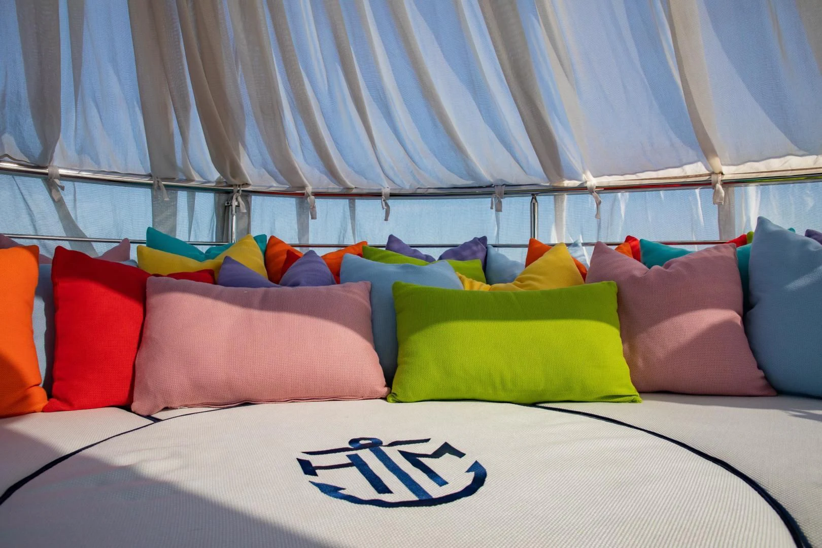a bed with a white sheet and colorful pillows aboard HATT MILL Yacht for Sale