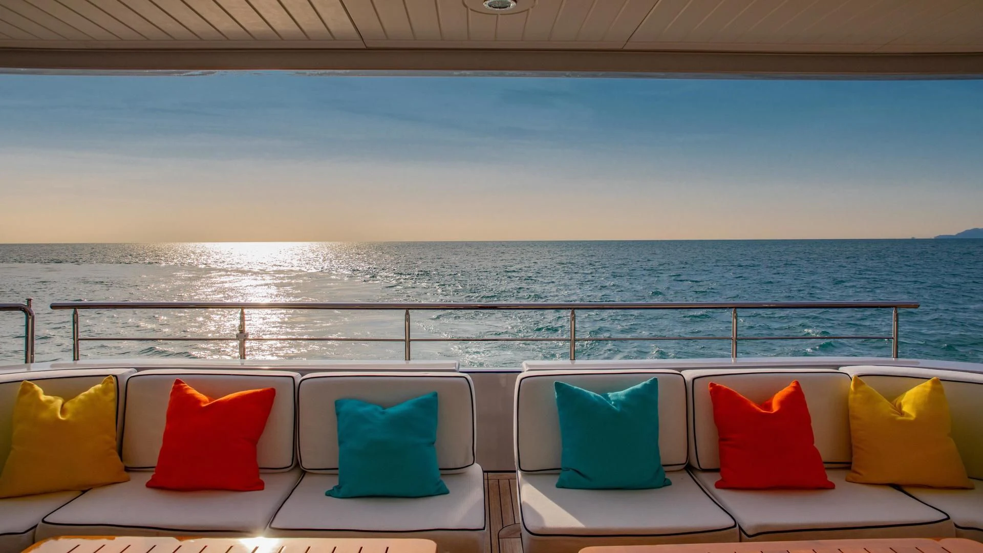 a couch and a table on a balcony overlooking a body of water aboard HATT MILL Yacht for Sale