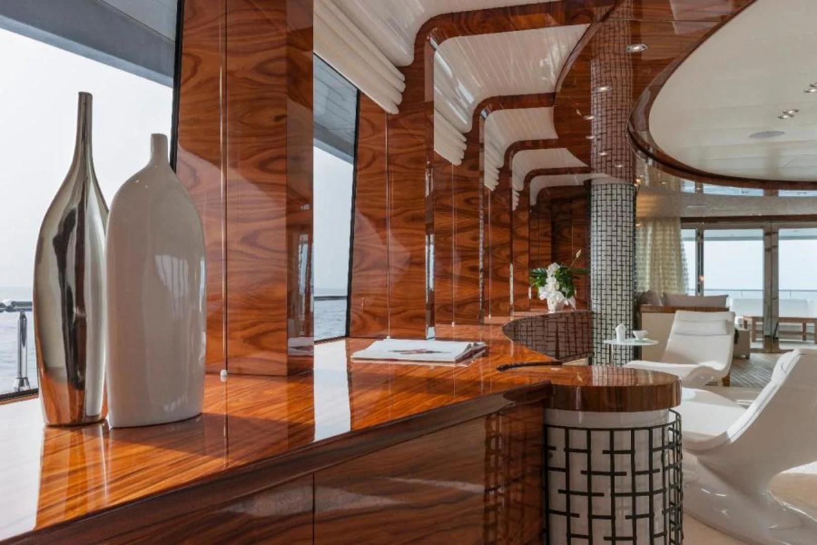 a room with a wood floor and a tall glass shelf with a bottle of wine and a glass aboard HATT MILL Yacht for Sale