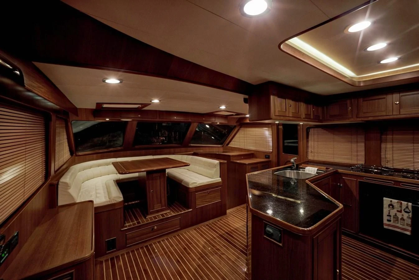 a room with wooden cabinets and a counter with a sink and a large window aboard BEN'S BARGE Yacht for Sale