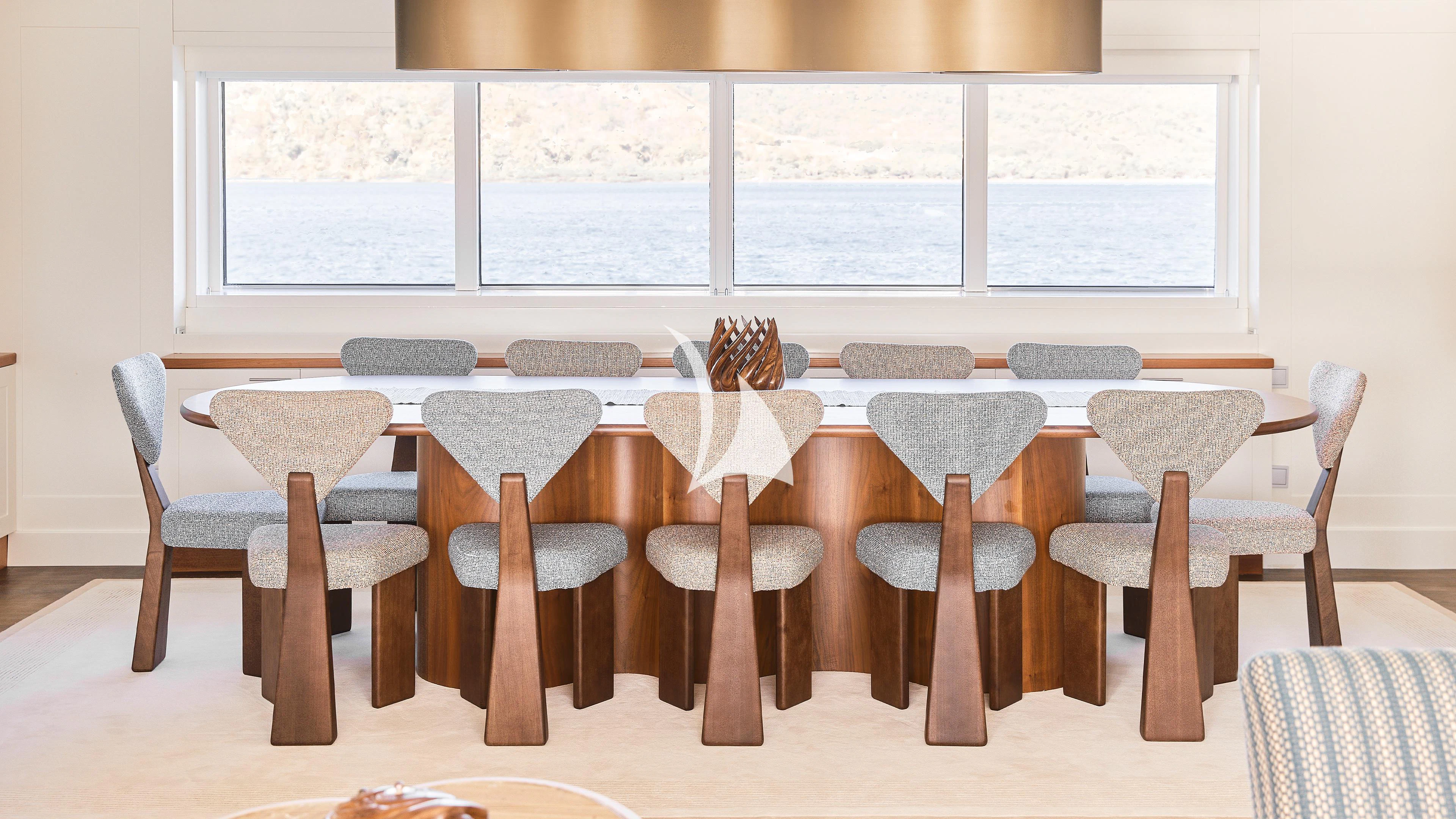 a group of wooden chairs and a table with a wood bench aboard SENSES Yacht for Sale