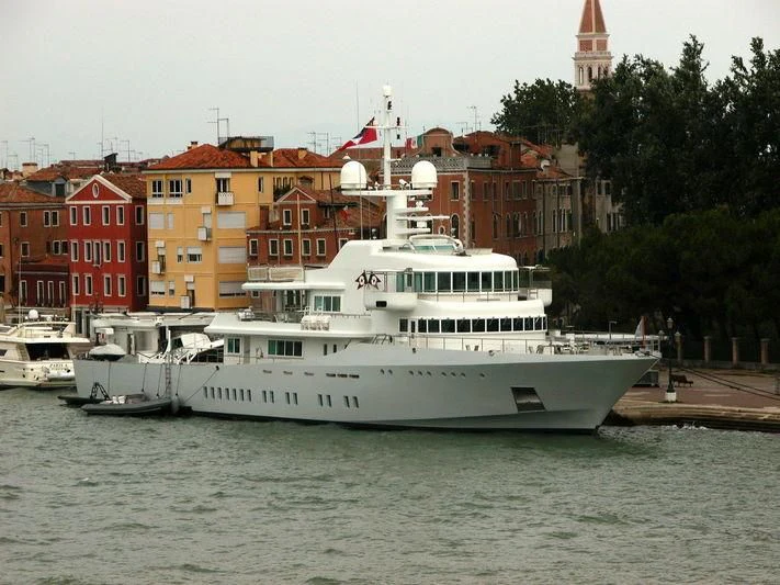 a large white boat in a harbor aboard SENSES Yacht for Sale