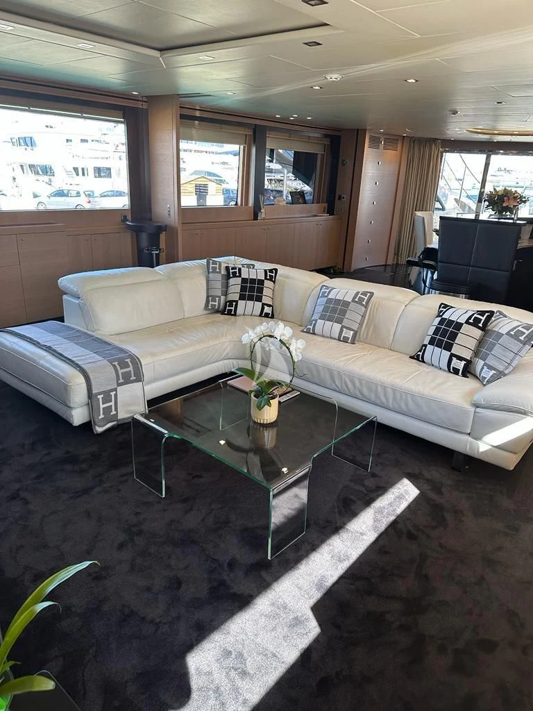 a living room with a couch and coffee table aboard YCM 120 Yacht for Charter