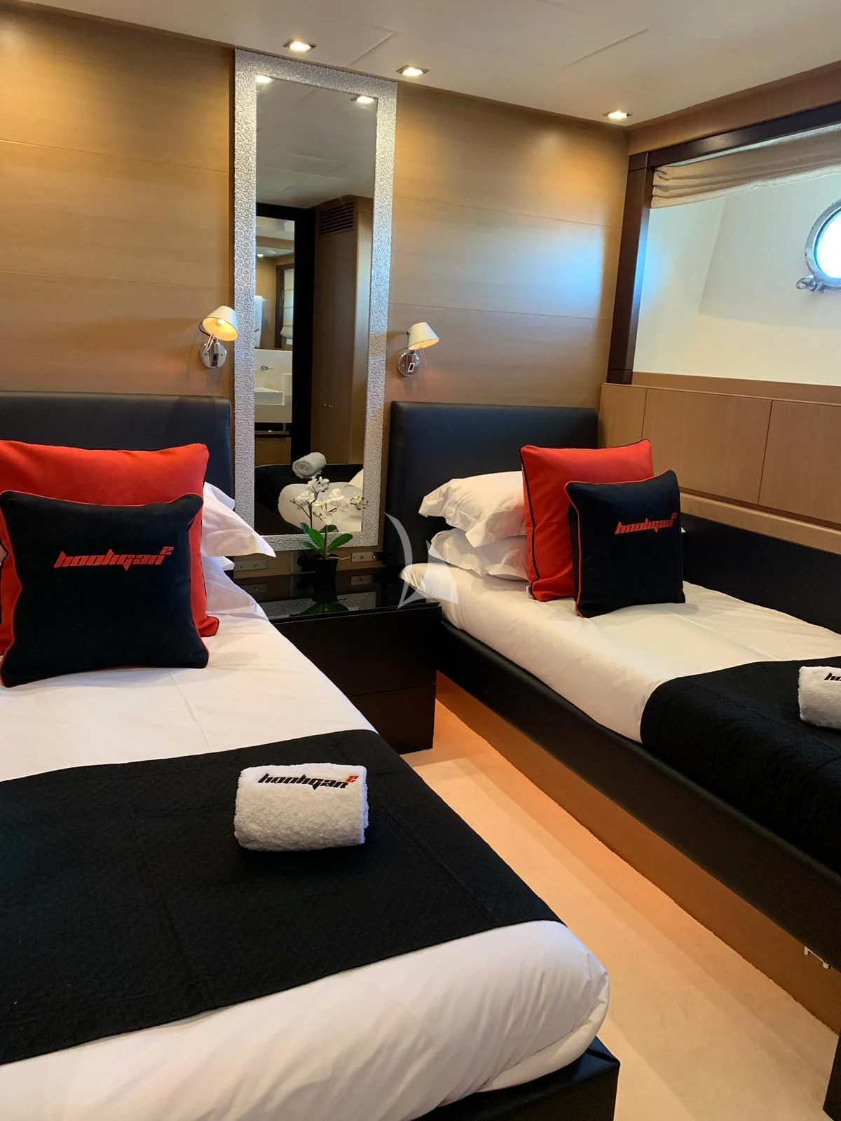 a room with beds and a mirror aboard YCM 120 Yacht for Charter