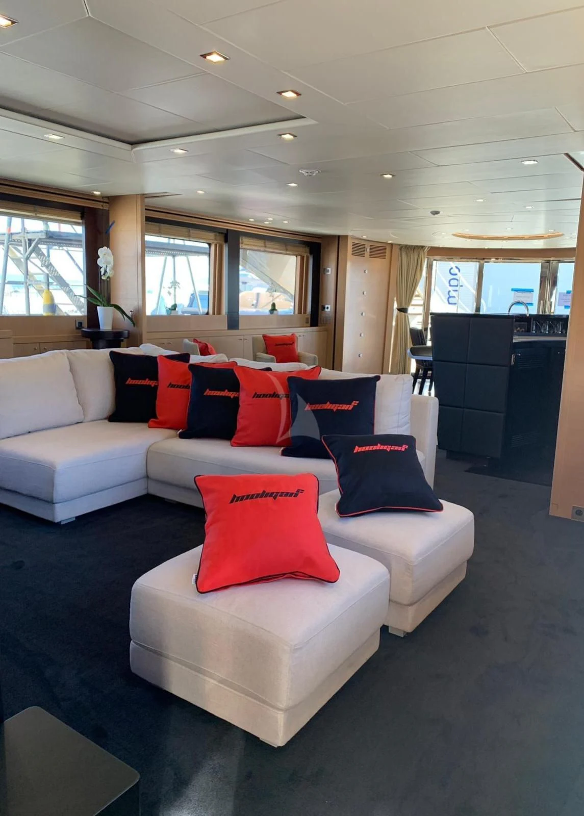 a white couch with red pillows aboard YCM 120 Yacht for Charter