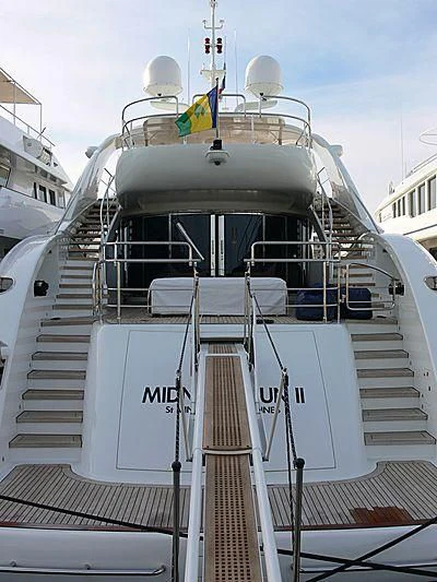 a white boat with a flag on it aboard YCM 120 Yacht for Charter
