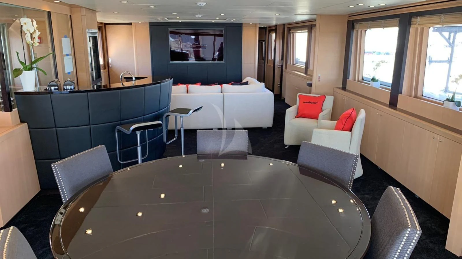 a large living room with a large table and chairs aboard YCM 120 Yacht for Charter