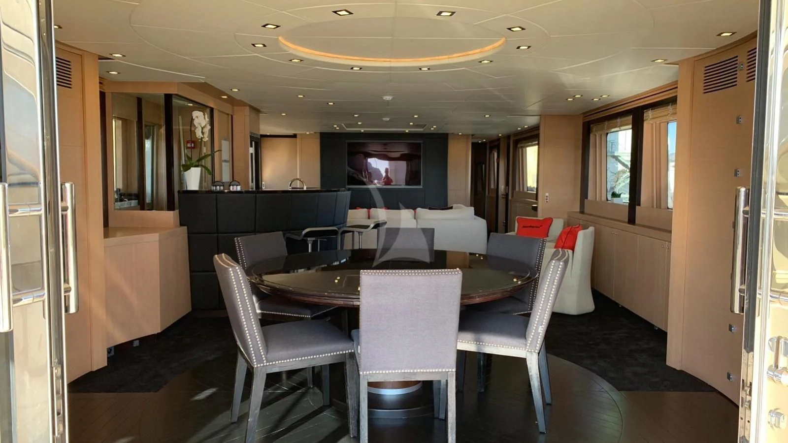 a large room with a table and chairs aboard YCM 120 Yacht for Charter