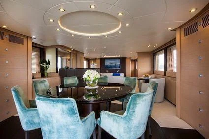 a large living room with a table and chairs aboard YCM 120 Yacht for Charter