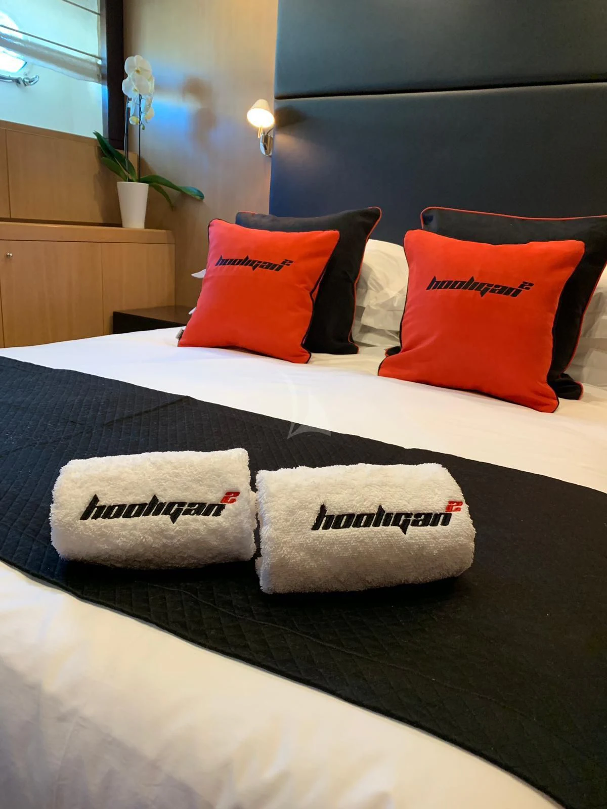 a bed with pillows and a remote aboard YCM 120 Yacht for Charter