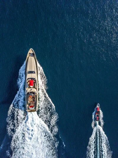 a white boat with red and blue sails aboard YCM 120 Yacht for Charter