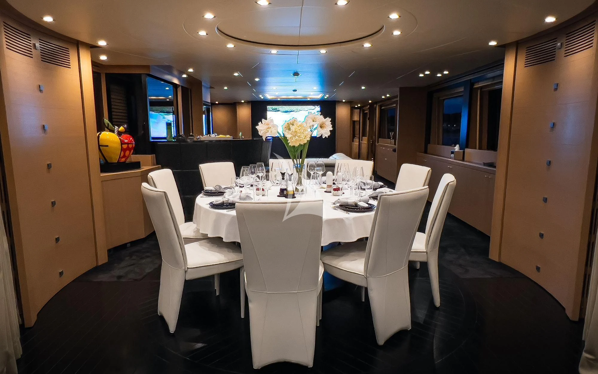 a dining room with white chairs aboard YCM 120 Yacht for Charter