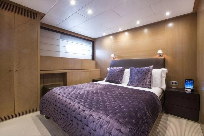 a room with a bed and a television aboard YCM 120 Yacht for Charter