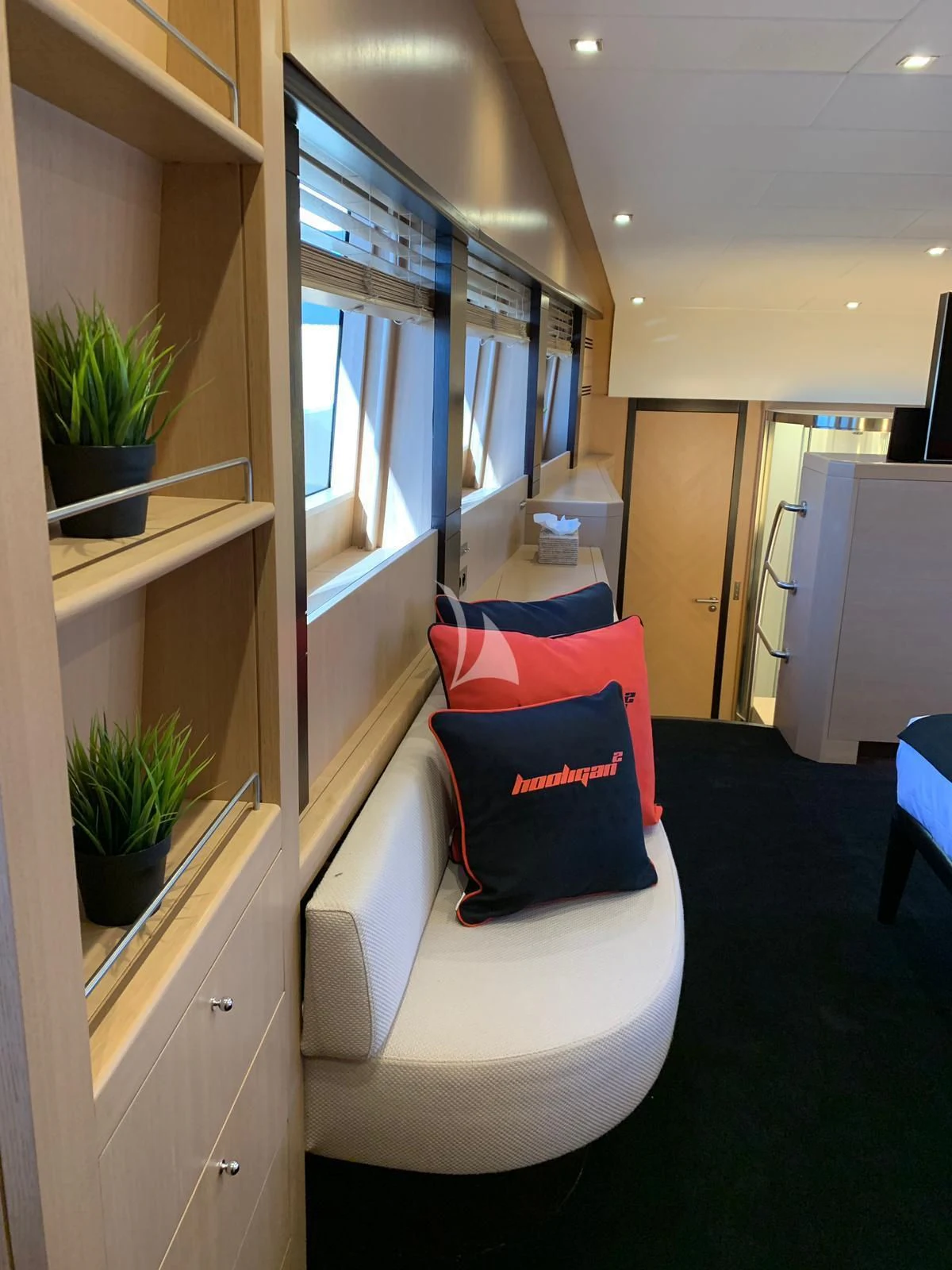 a room with a couch and a plant in it aboard YCM 120 Yacht for Charter