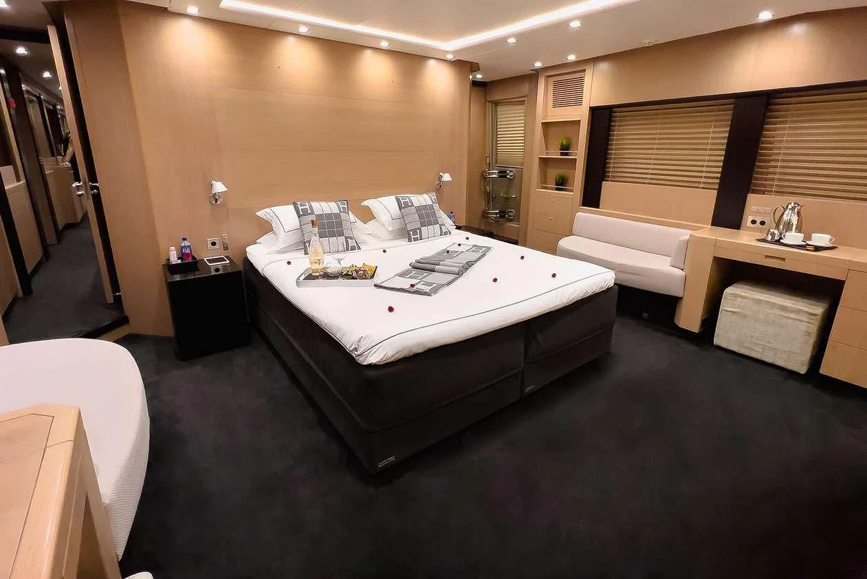 a hotel room with a bed and desk aboard YCM 120 Yacht for Charter