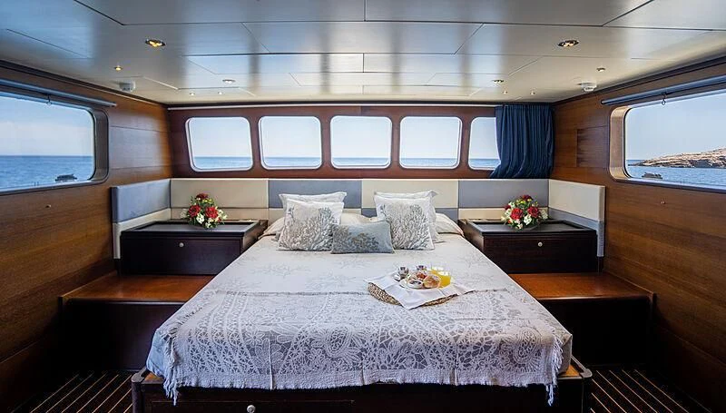 a bed with white sheets and pillows aboard SEMAYA Yacht for Sale