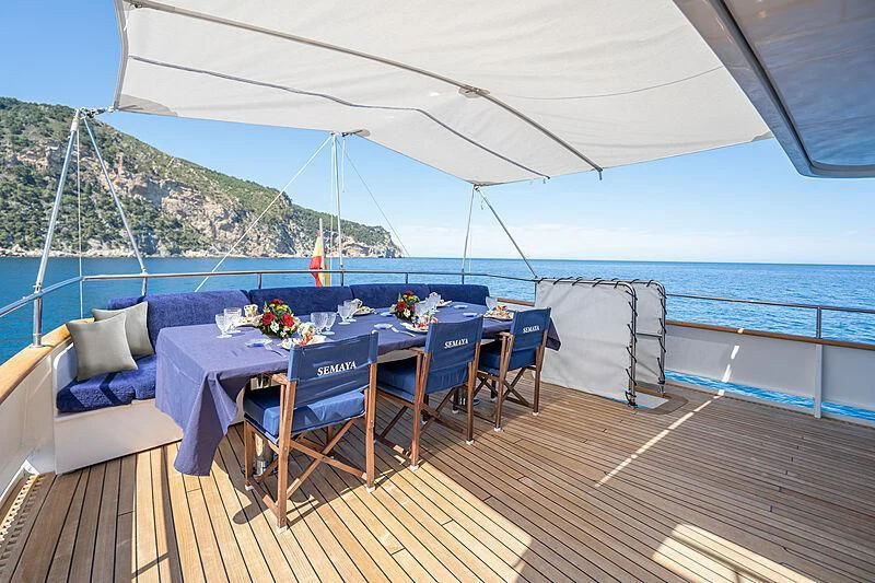 a deck with a table and chairs on it aboard SEMAYA Yacht for Sale