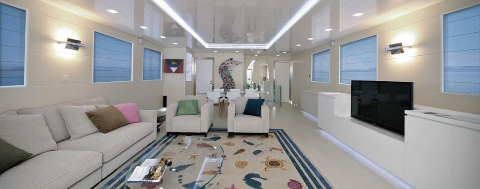 a living room with a blue and white rug aboard OCEAN KING 88 Yacht for Sale
