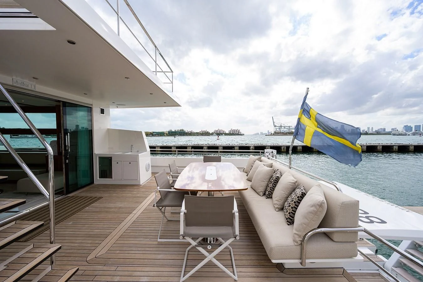 a deck with a couch and a table and chairs on it aboard SOCIAL DISTANCING Yacht for Sale