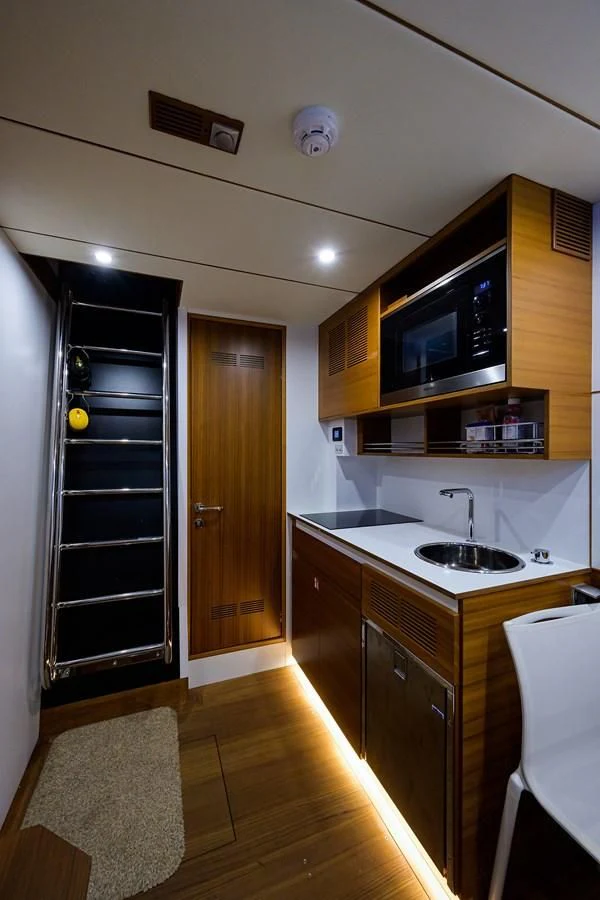 a kitchen with a black refrigerator aboard SOCIAL DISTANCING Yacht for Sale