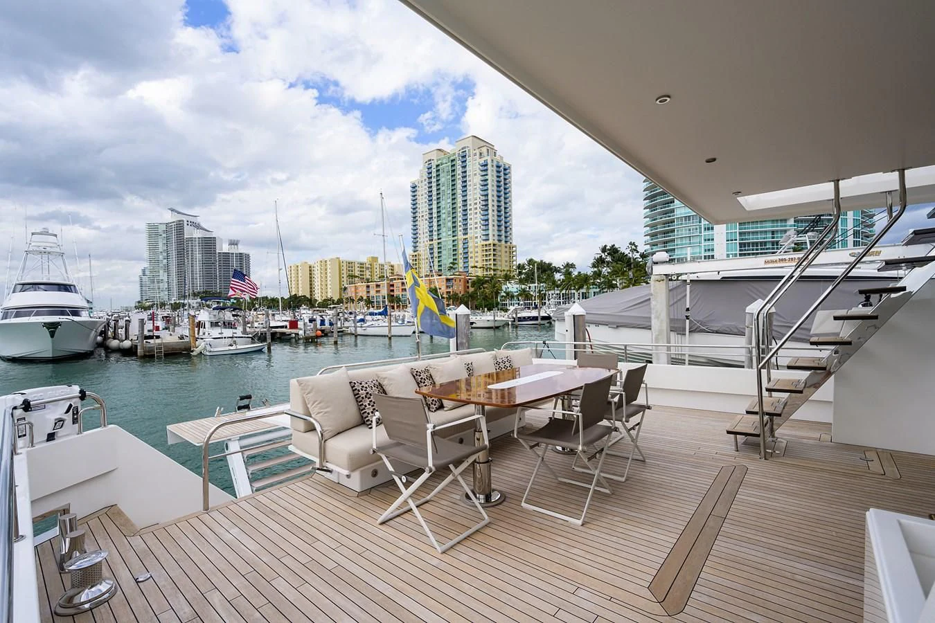 a deck with a table chairs and a view of a city aboard SOCIAL DISTANCING Yacht for Sale