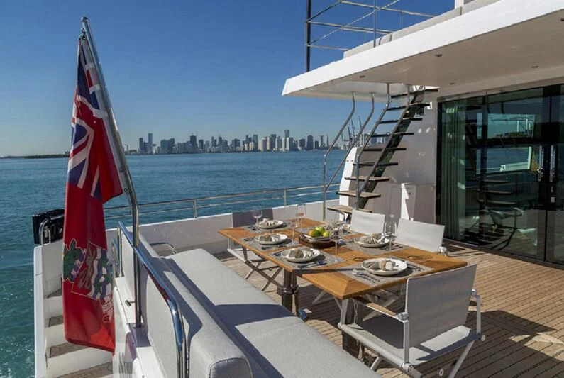 a table and chairs on a deck overlooking a city aboard SOCIAL DISTANCING Yacht for Sale