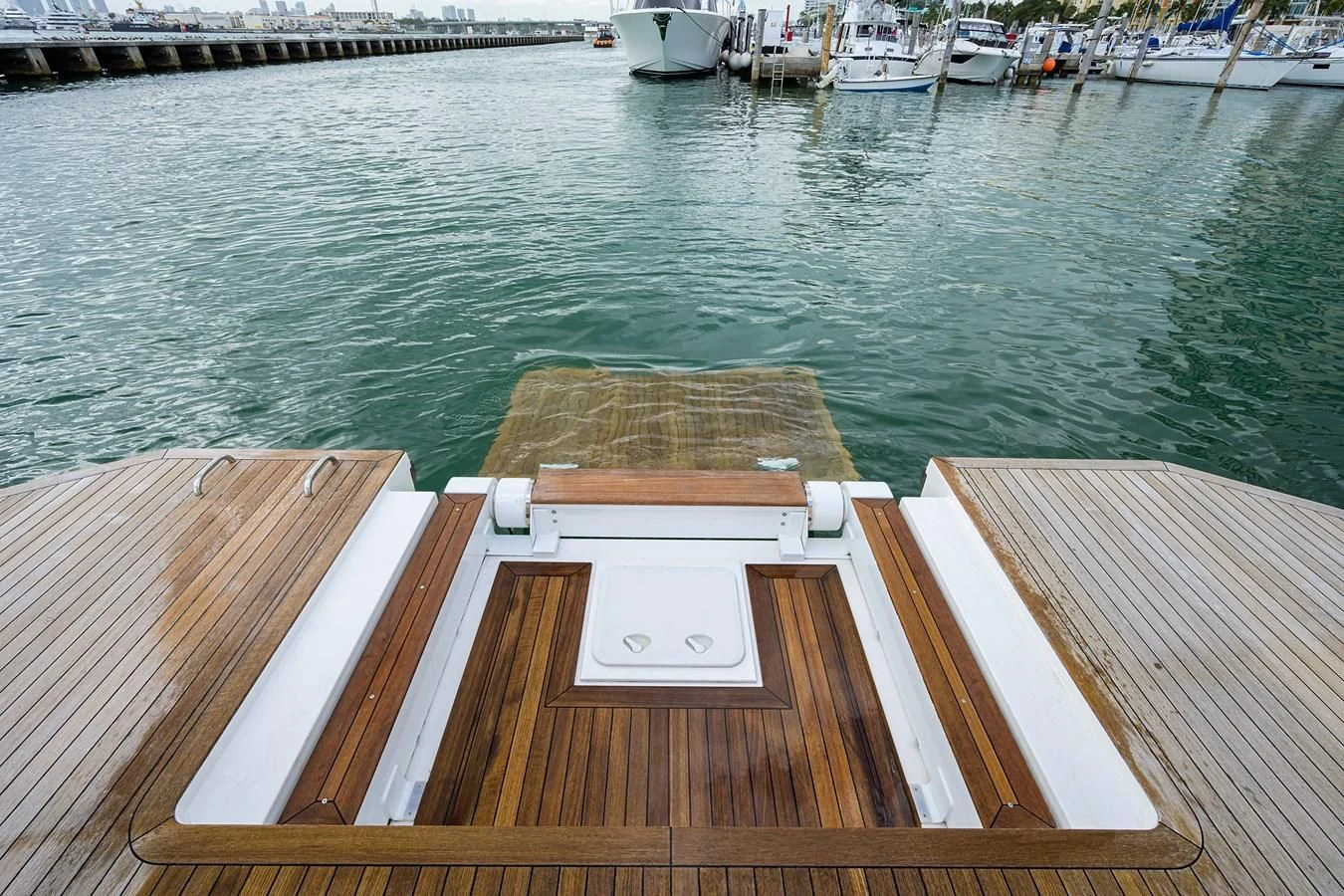 a wooden dock with a railing and boats in the background aboard SOCIAL DISTANCING Yacht for Sale