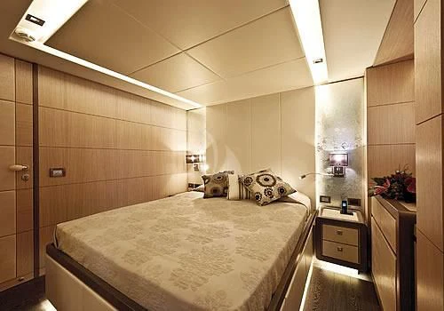 a bedroom with a bed and a mirror aboard MUSA Yacht for Sale
