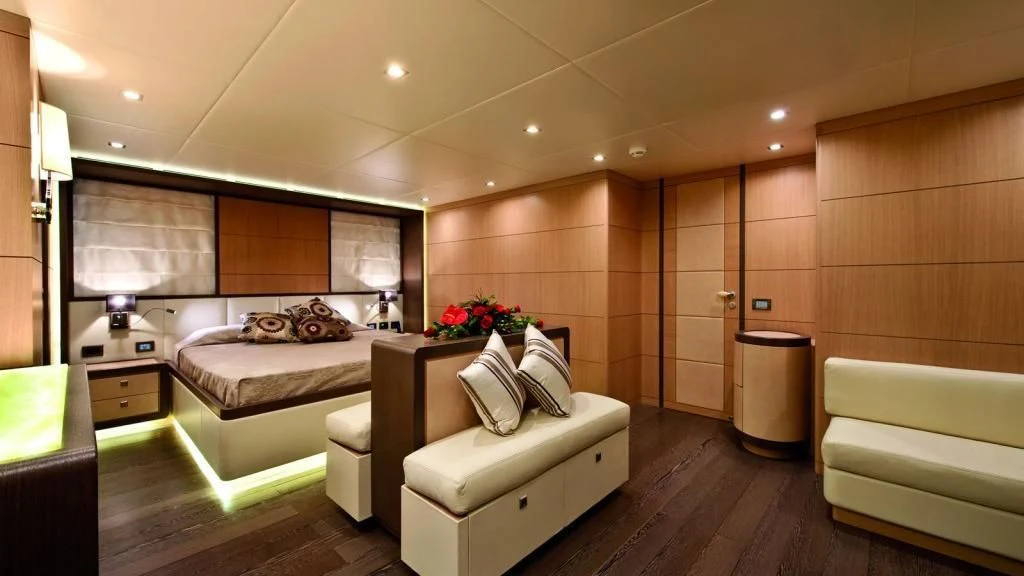 a room with a bed and a couch aboard MUSA Yacht for Sale