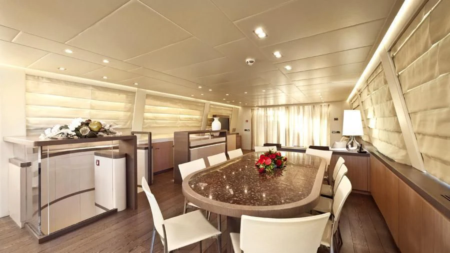 a large kitchen with a table and chairs aboard MUSA Yacht for Sale