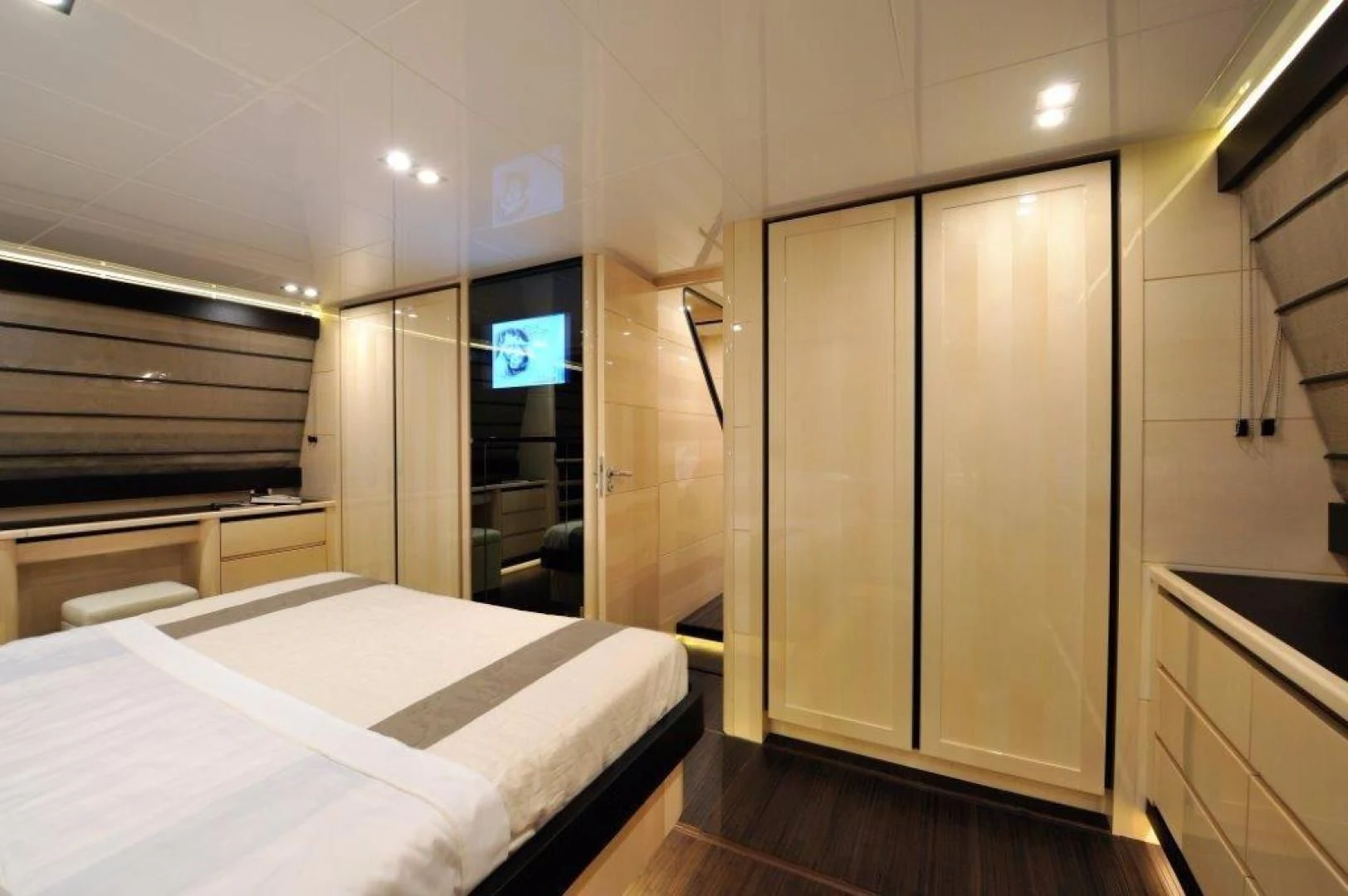 a room with a bed and a tv on the wall aboard ELLISIUM Yacht for Sale
