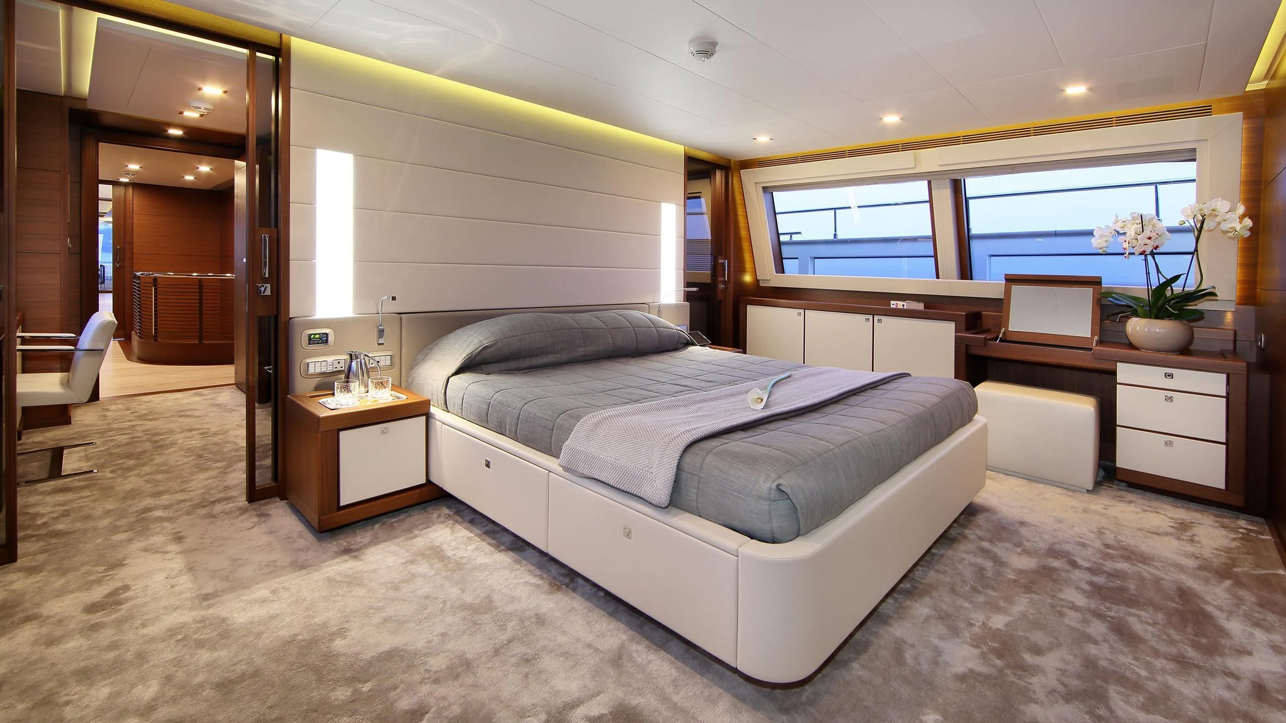 a bedroom with a bed desk and a window aboard VELA Yacht for Sale