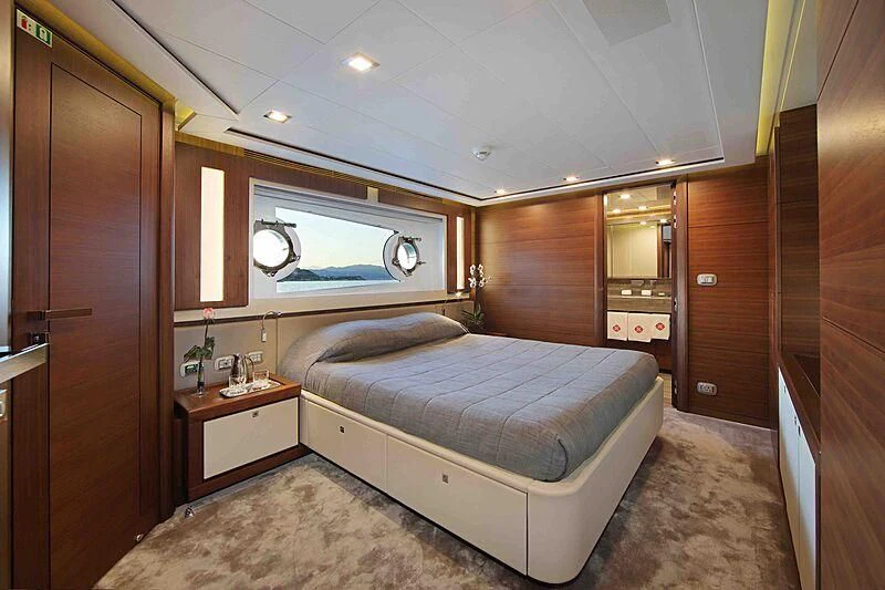 a bedroom with a bed and a window aboard VELA Yacht for Sale