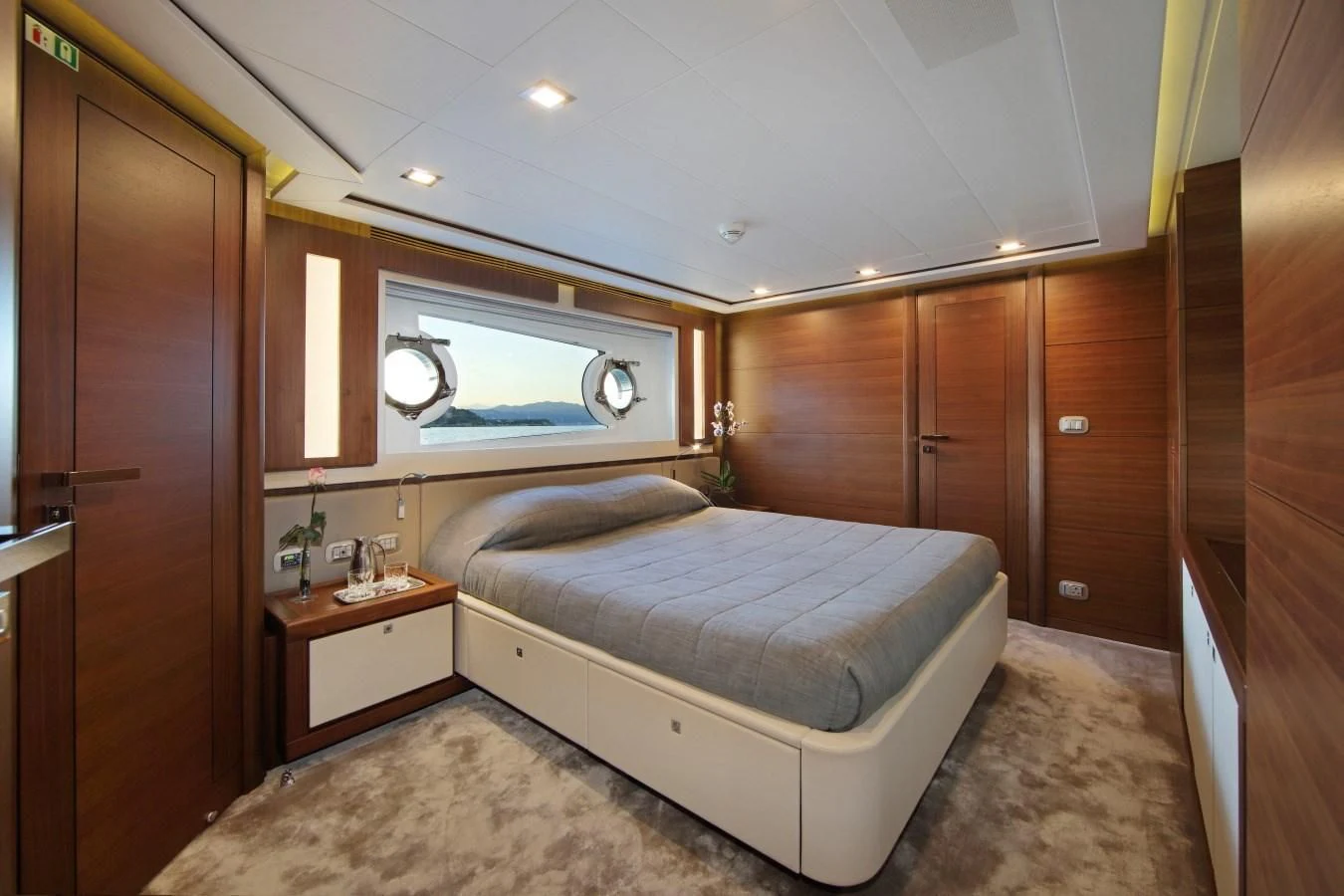 a bedroom with a bed and a window aboard VELA Yacht for Sale