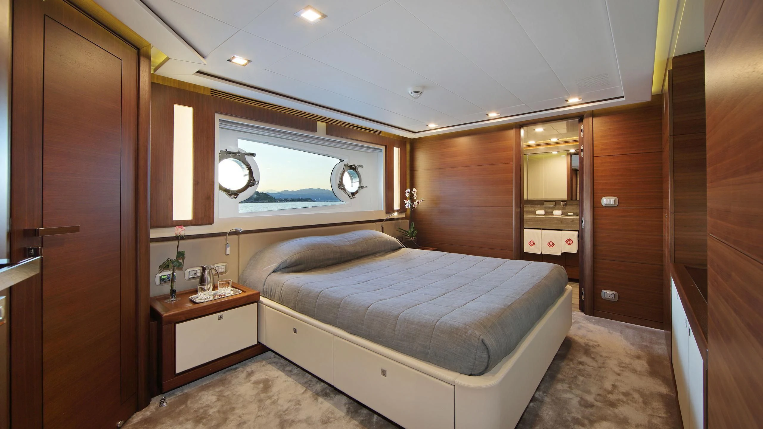 a bedroom with a bed and a window aboard VELA Yacht for Sale