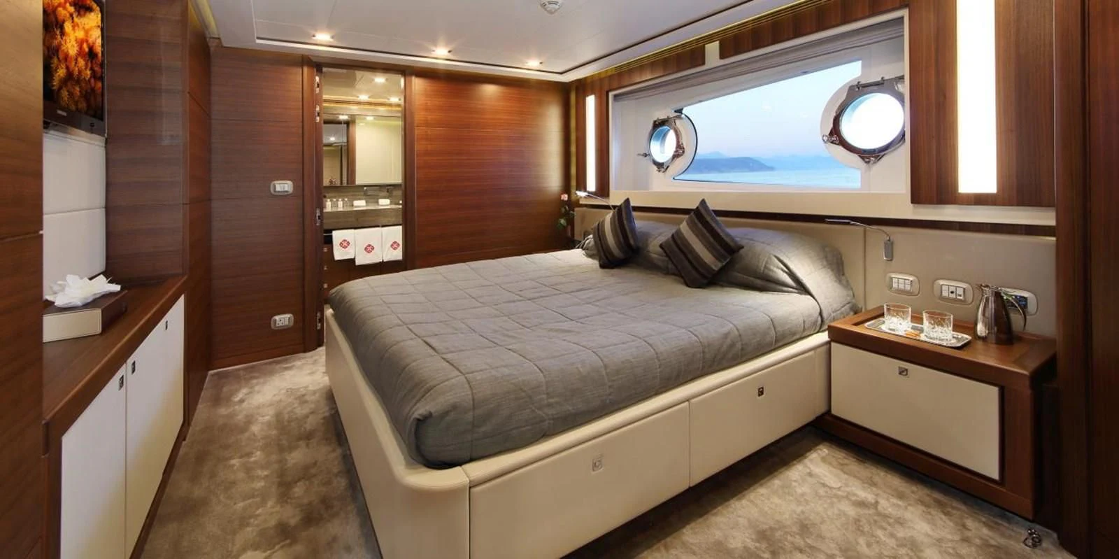 a bedroom with a bed and a desk aboard VELA Yacht for Sale