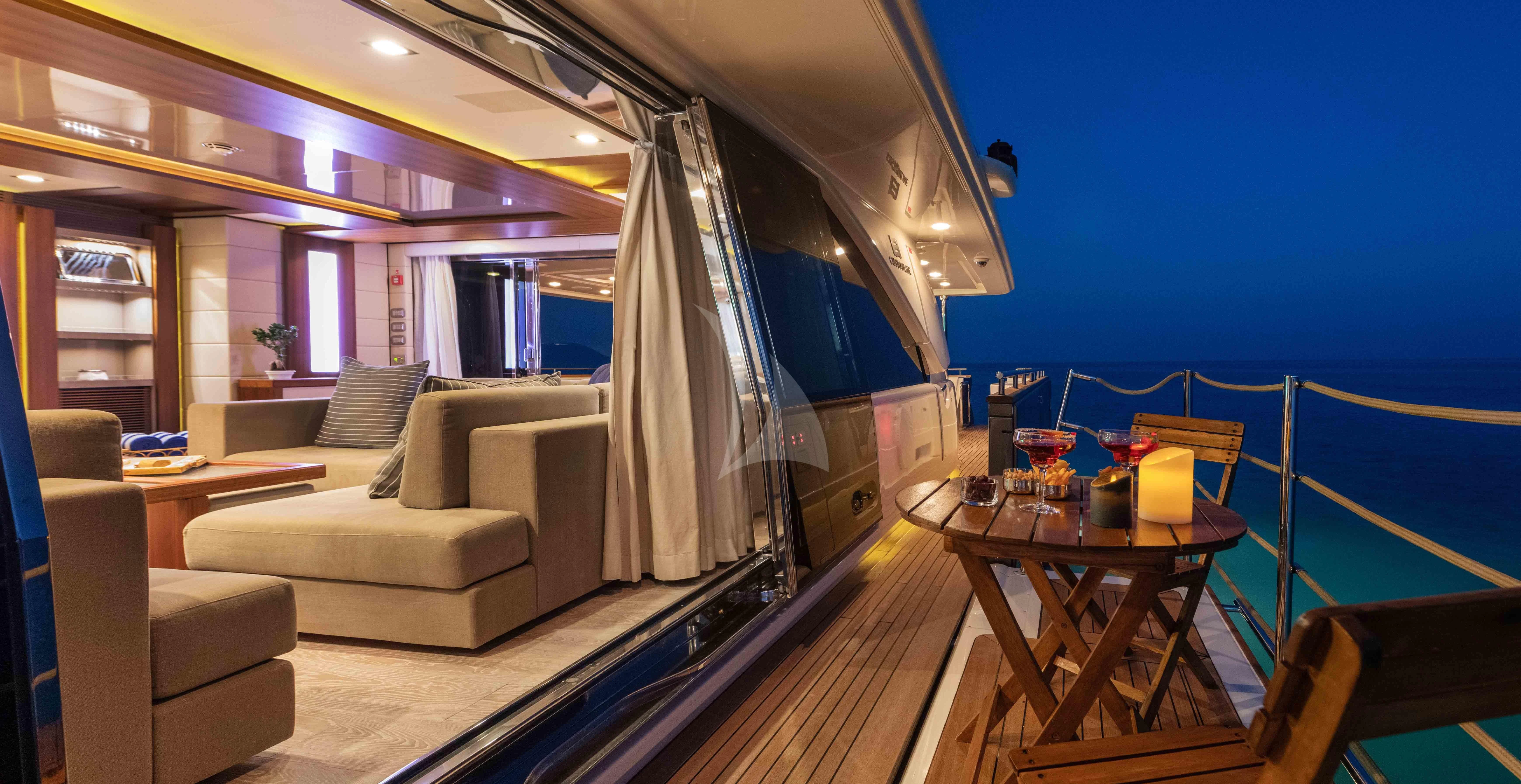 a living room with a table and couches aboard VELA Yacht for Sale