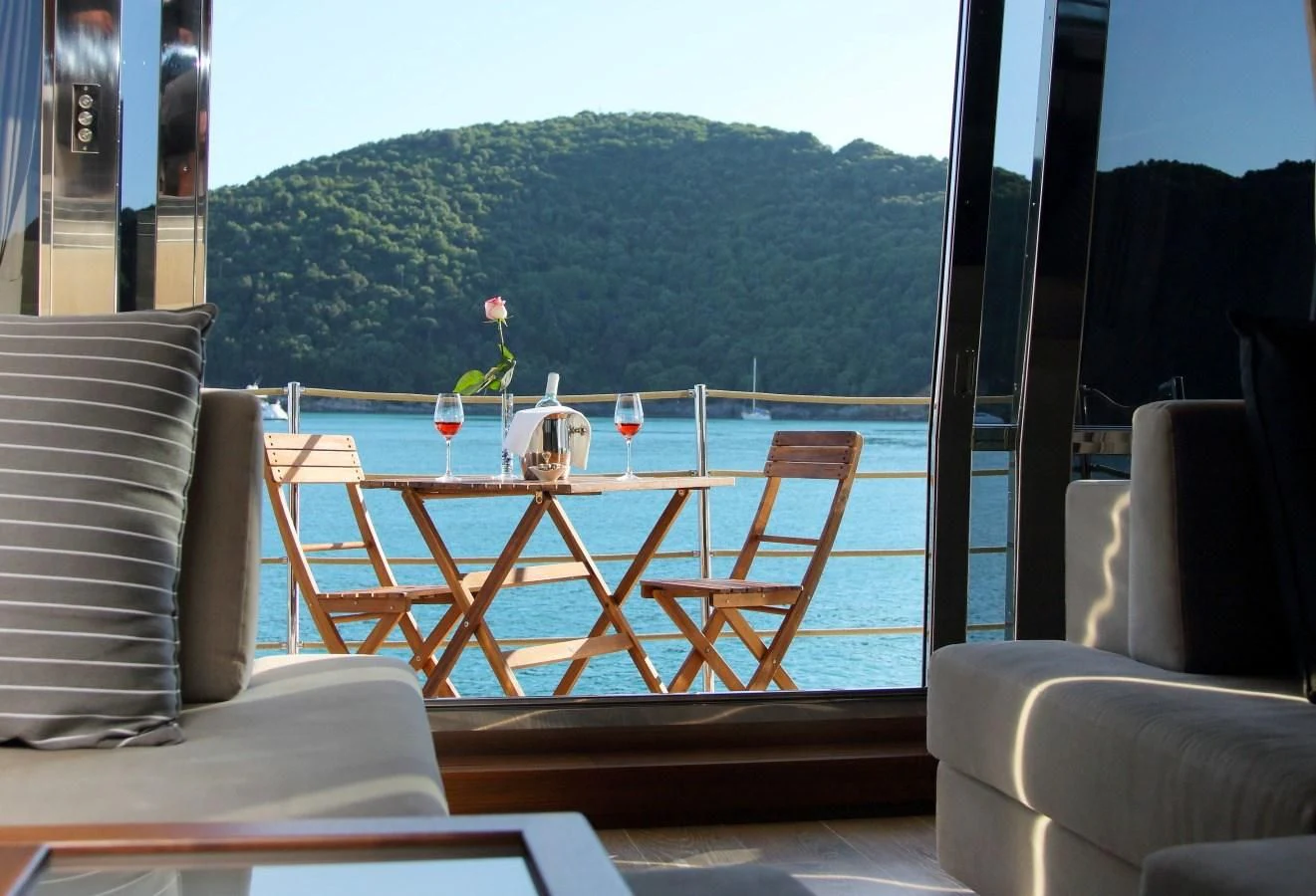 a deck with chairs and a table aboard VELA Yacht for Sale