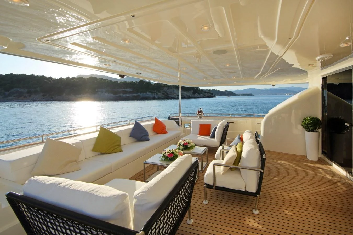 a room with a couch and a table and chairs on a deck aboard VELA Yacht for Sale